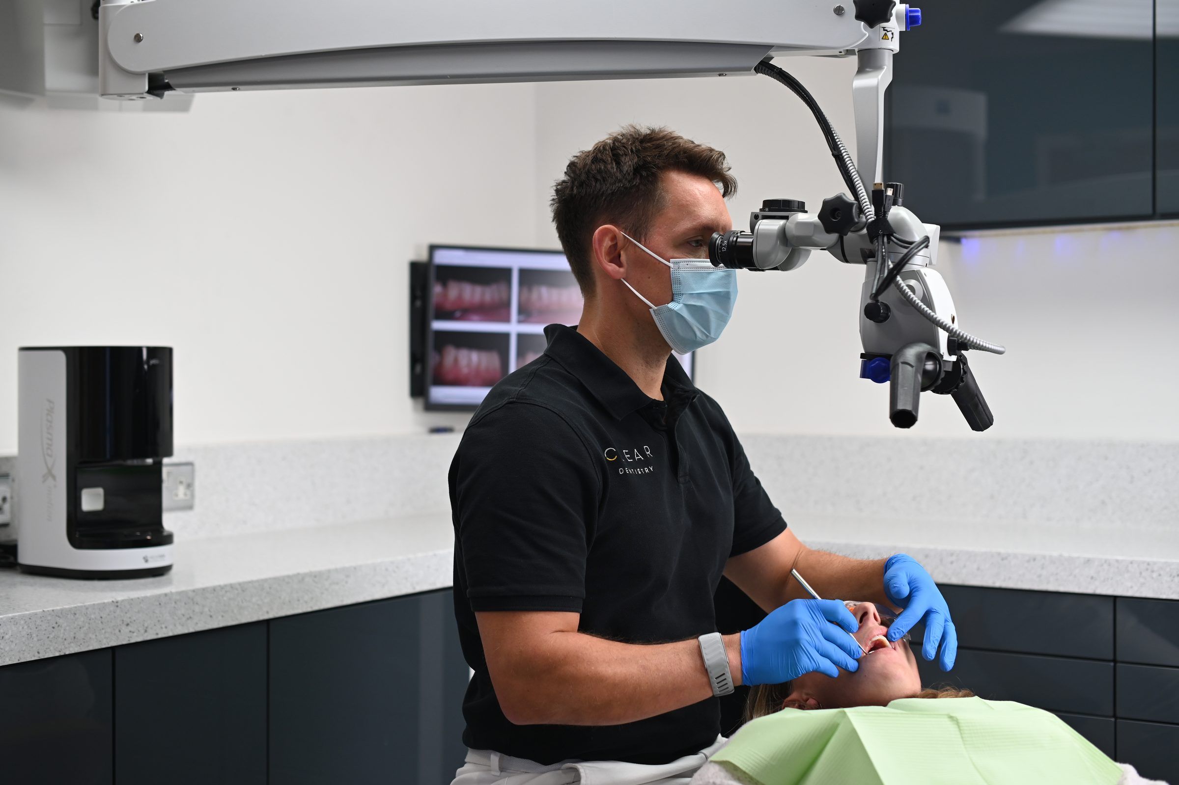 Dentist treating a patient under the surgical microscope