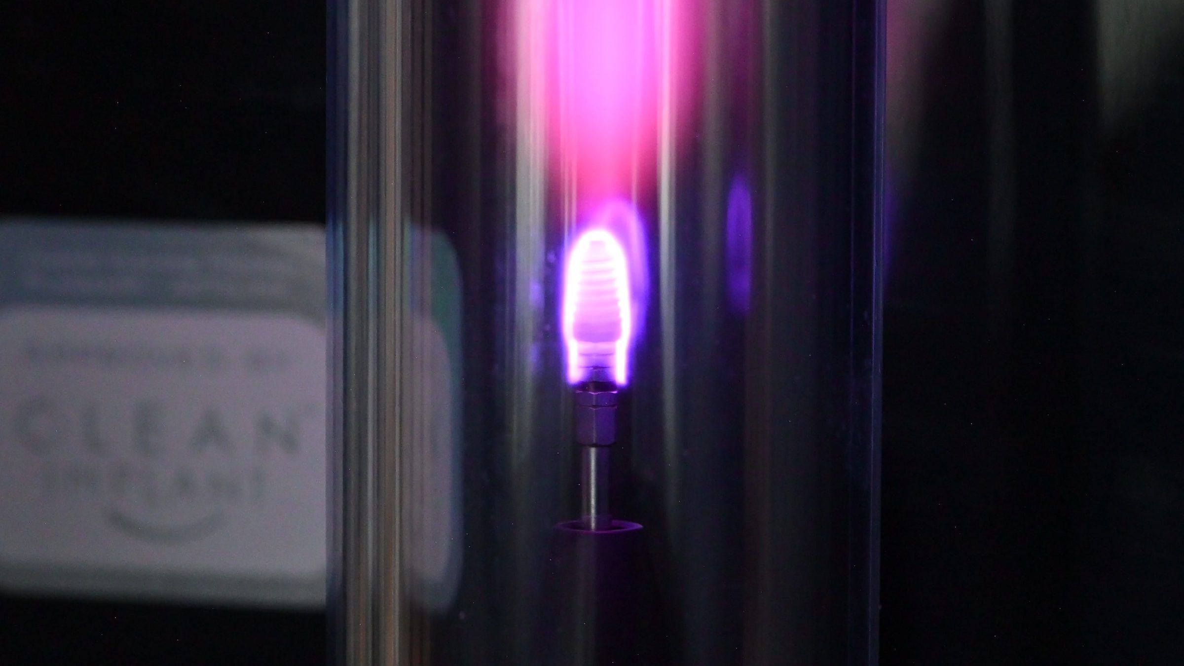A dental implant being plasma-activated before placement